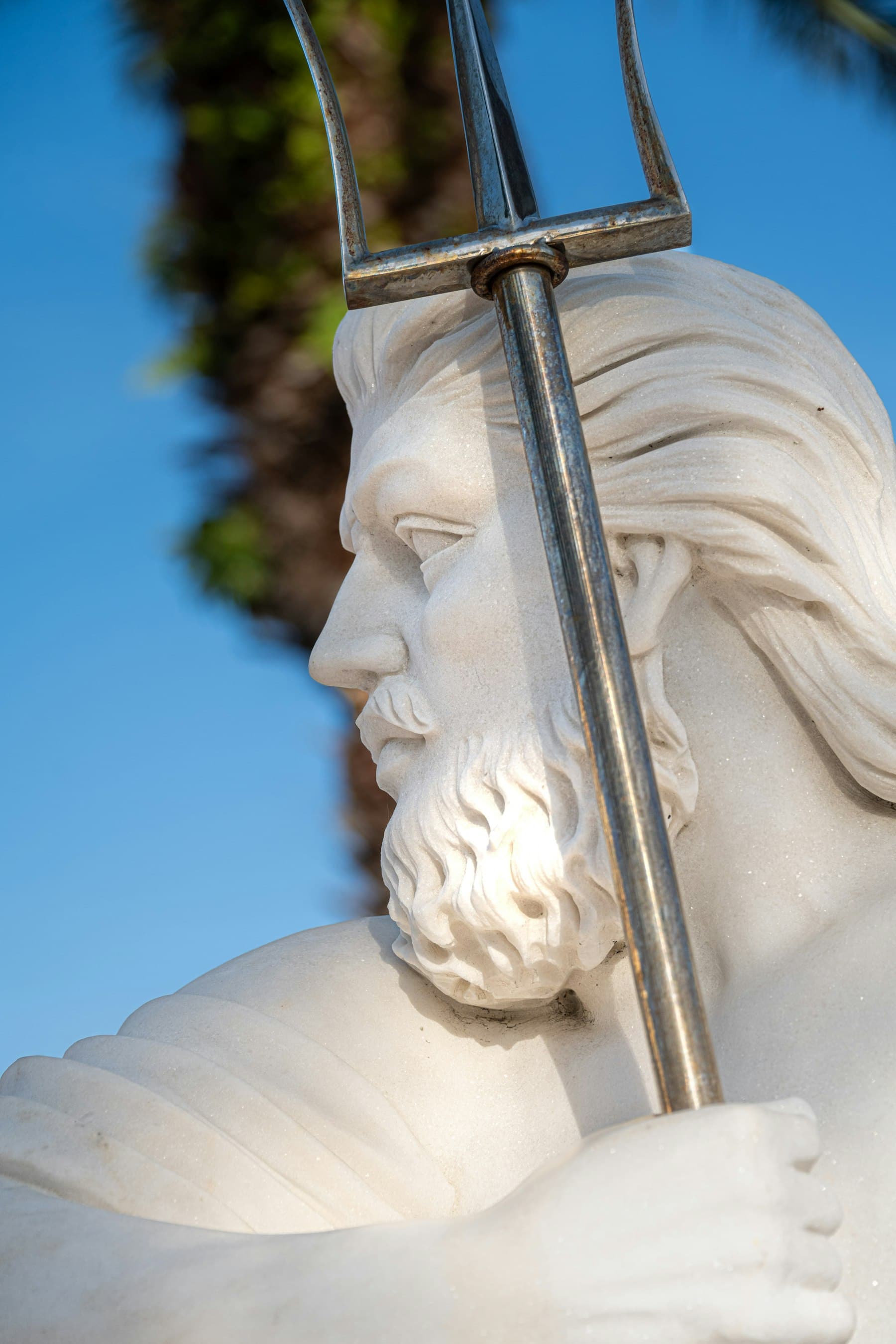 A marble statue with a sculptor's tool resting against it